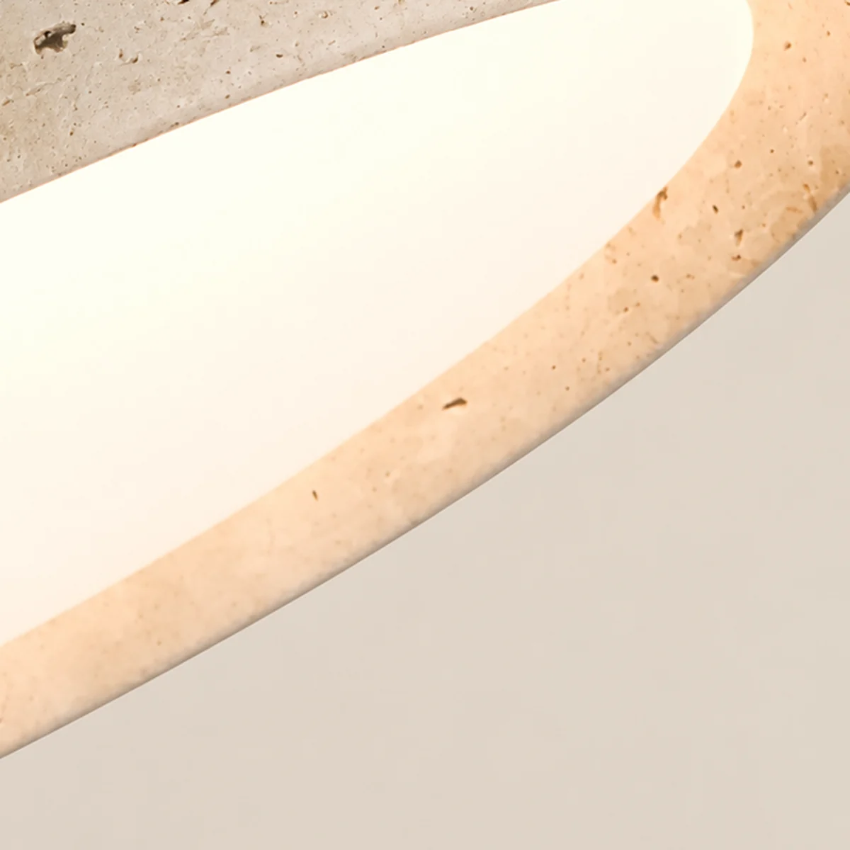 Close view of the lit acrylic diffuser inside the travertine shade
