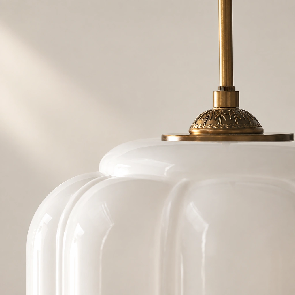 Close-up of the brass upper cap where the Lumi Eloise suspension rod meets the white glass shade