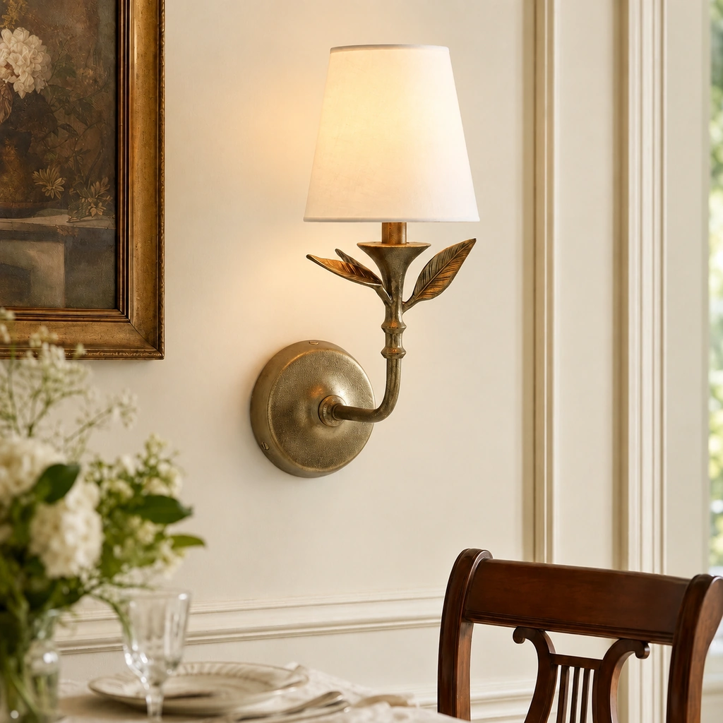 Celia leaf-stem sconce on a wall beside a framed painting and dining chair