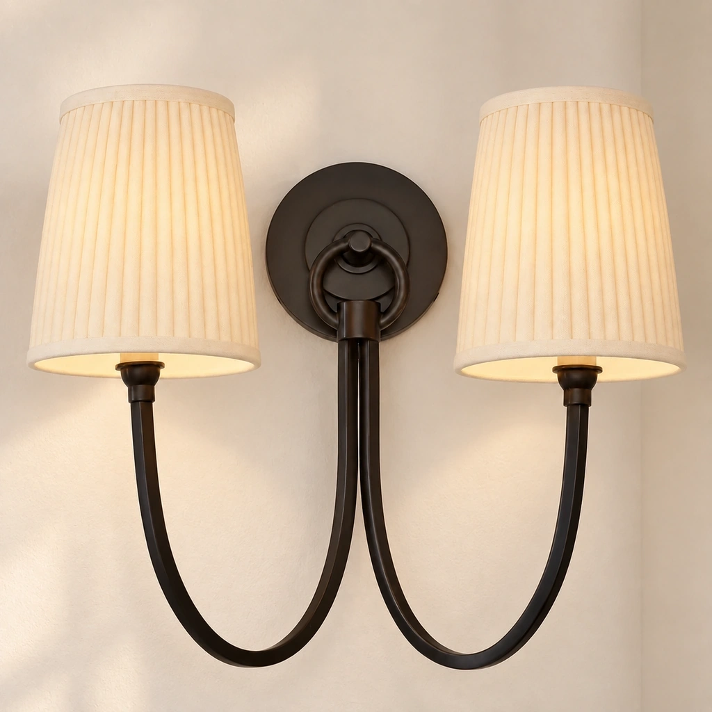 Complete view of the warmly lit Hollis wall fixture with black curved arms and pleated tapered linen shades