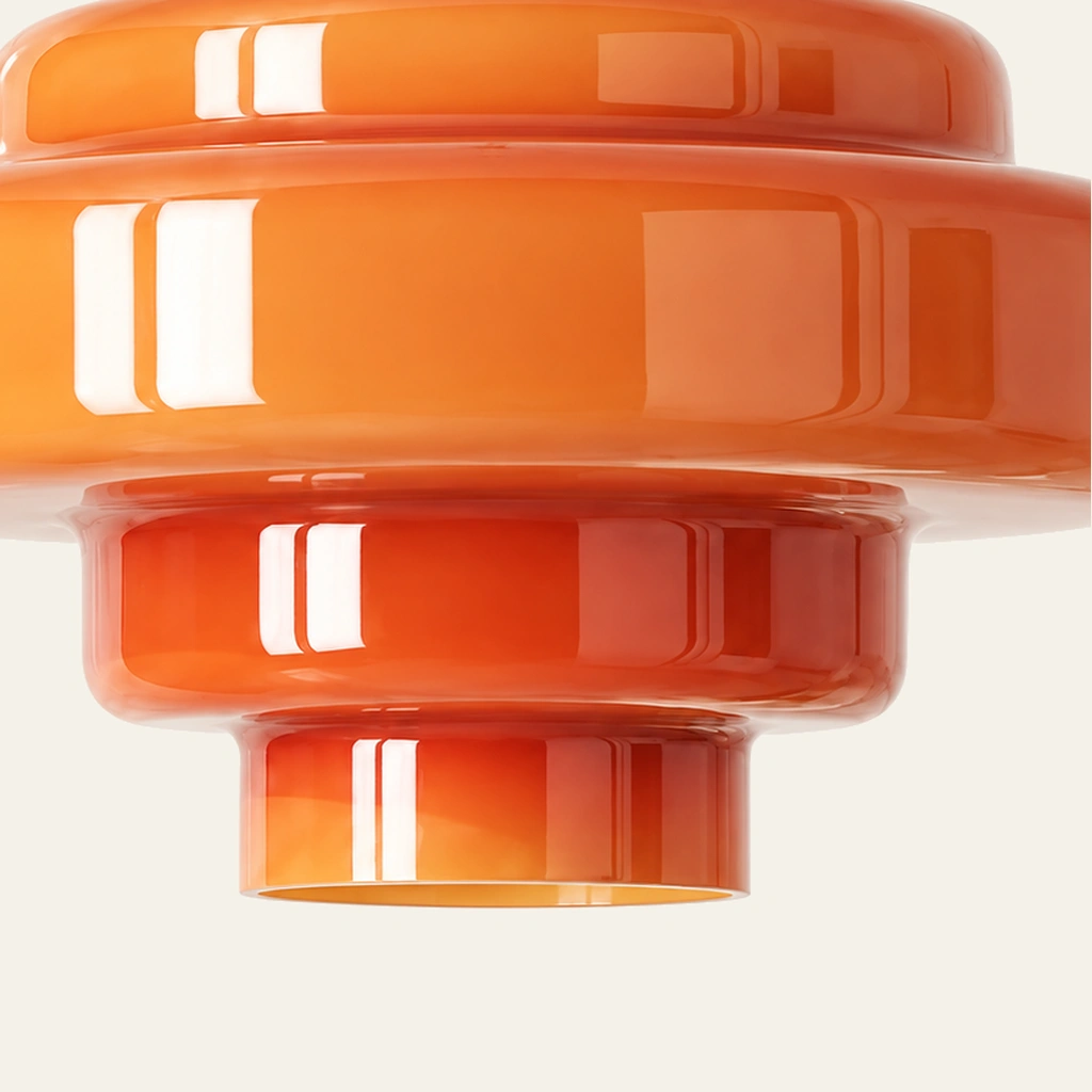 Rounded edges of the orange Mirelle glass shade on an ivory background