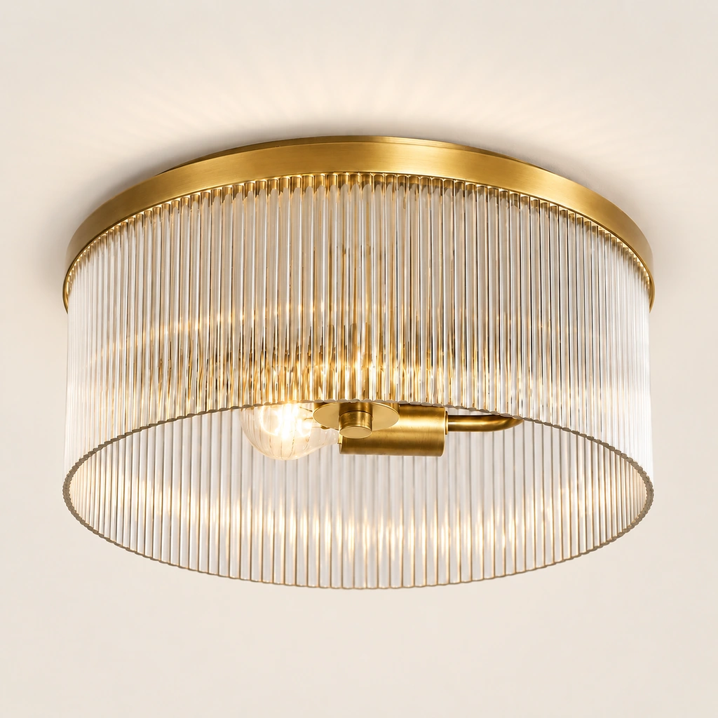 Tumbled Brass Vesper flush mount with ribbed glass drum on a plain background