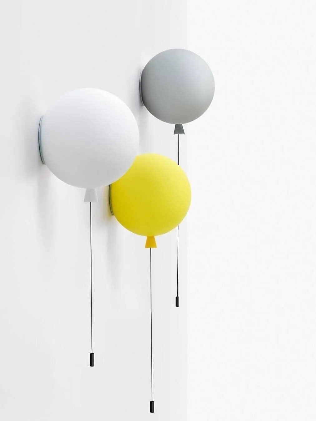 Un agencement mixte de lampes murales en forme de ballons jaunes, blancs et gris