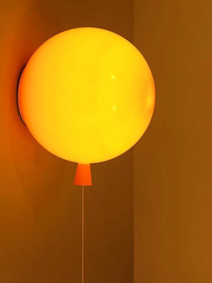 L'applique murale en forme de ballon jaune souvenir est allumée.