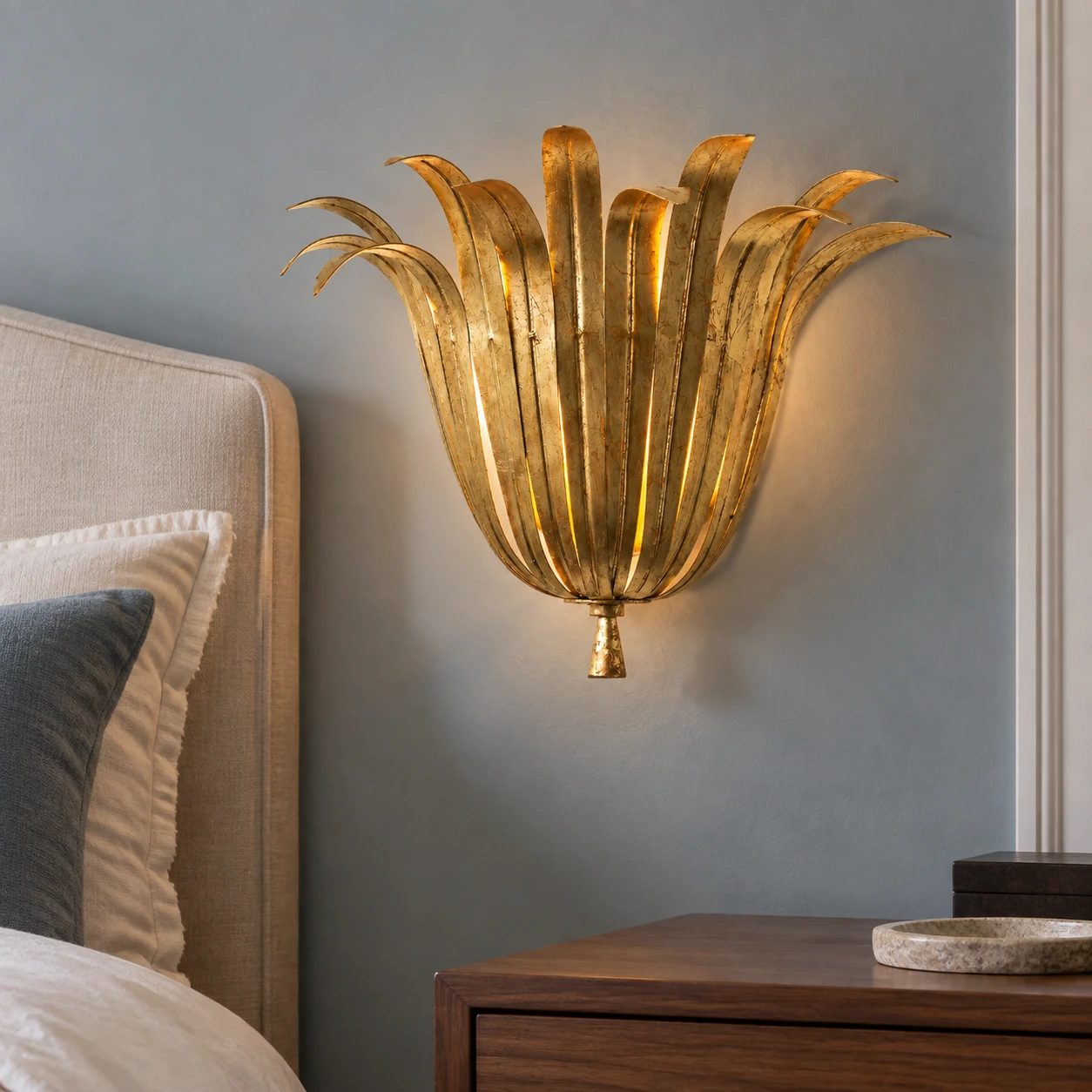 Vintage Gold Leaf wall sconce beside an upholstered bed