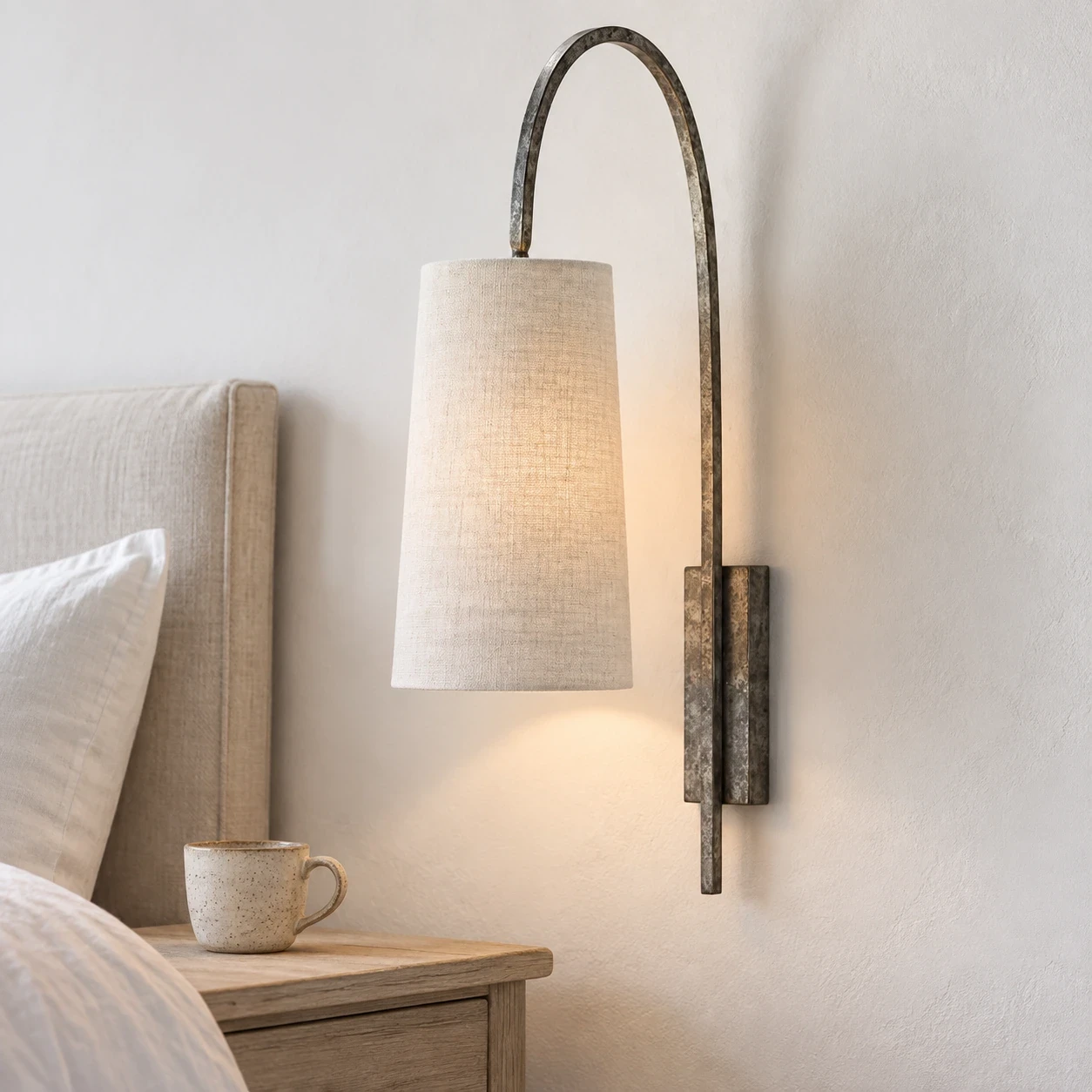 Antique Silver fabric wall sconce beside a bed