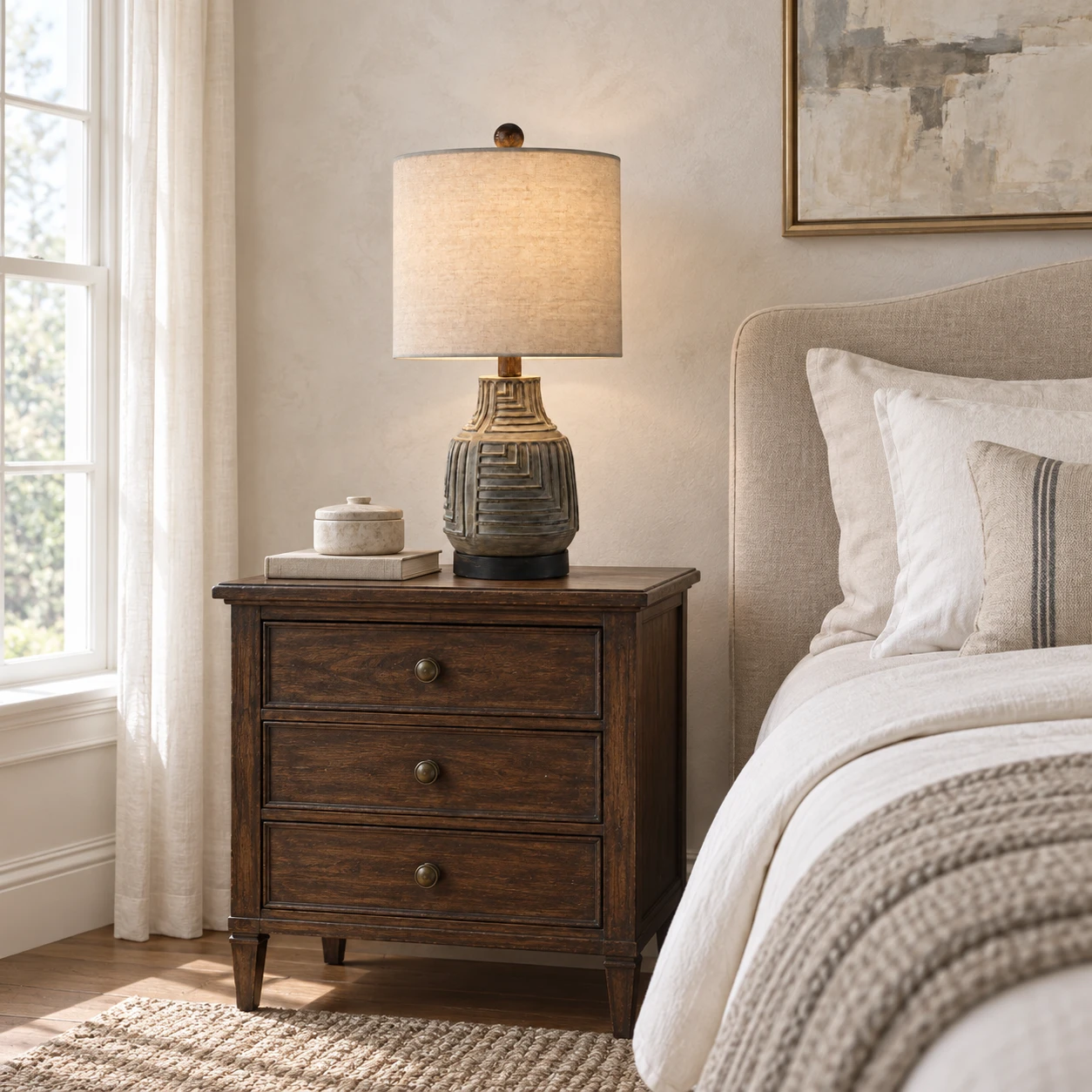 Carved wood table lamp beside a calm bedroom