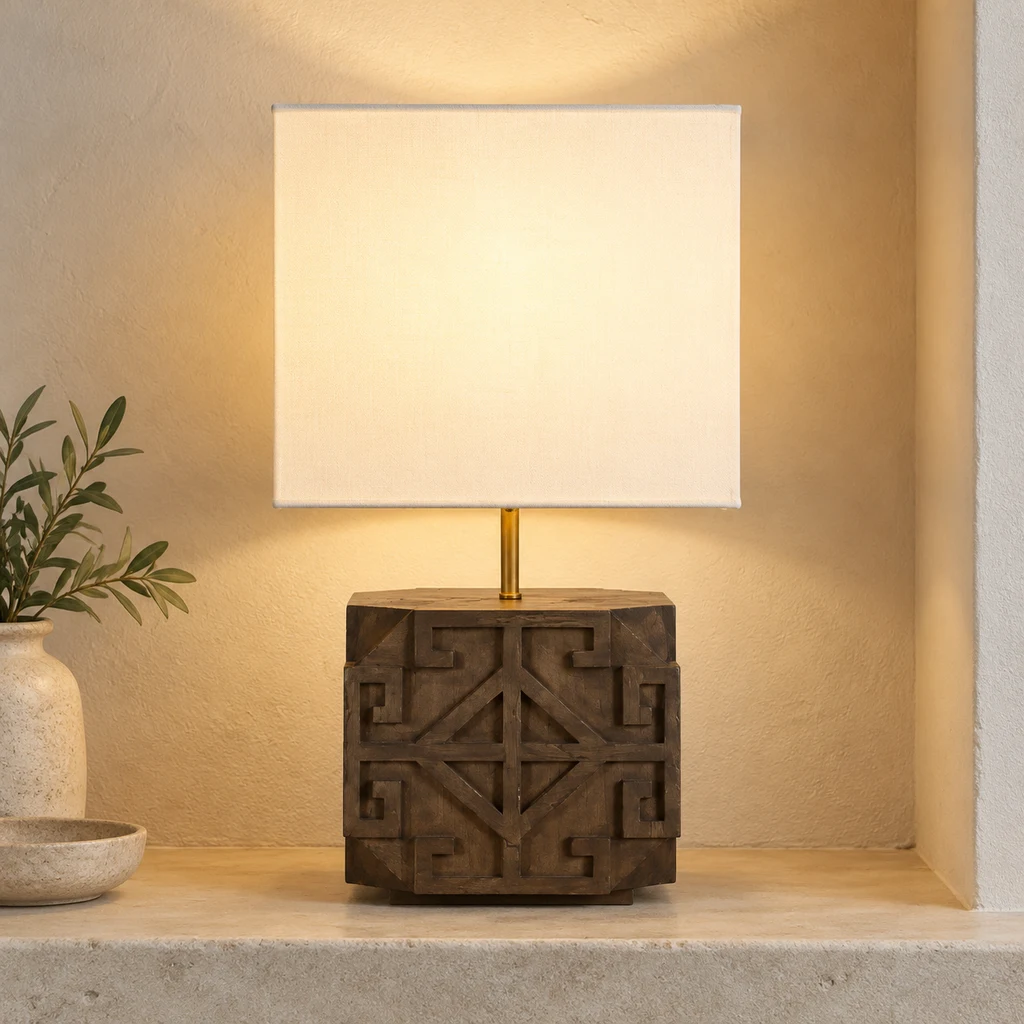 Aurelia carved wood table lamp with a white rectangular fabric shade, switched on in a pale architectural niche