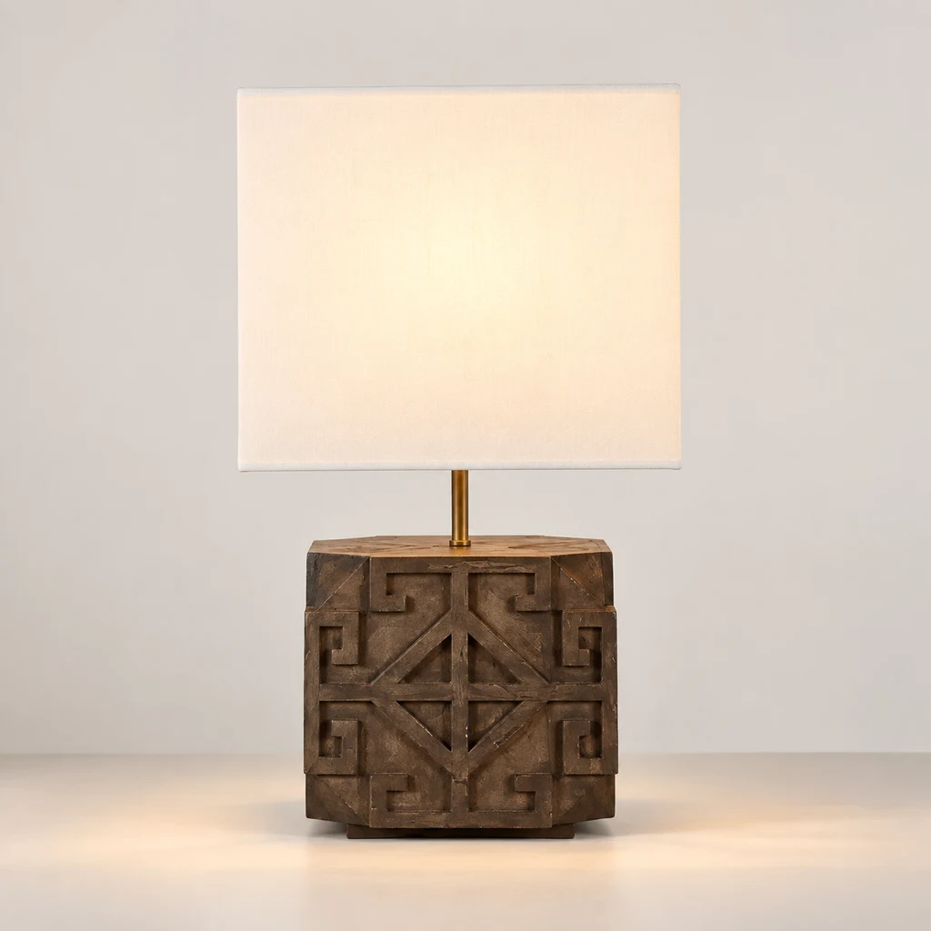 Aurelia carved wood table lamp switched on with a soft localized glow