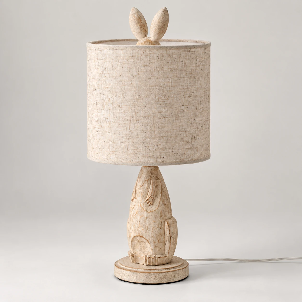Elsie bunny-carved wood table lamp switched off on a neutral studio background