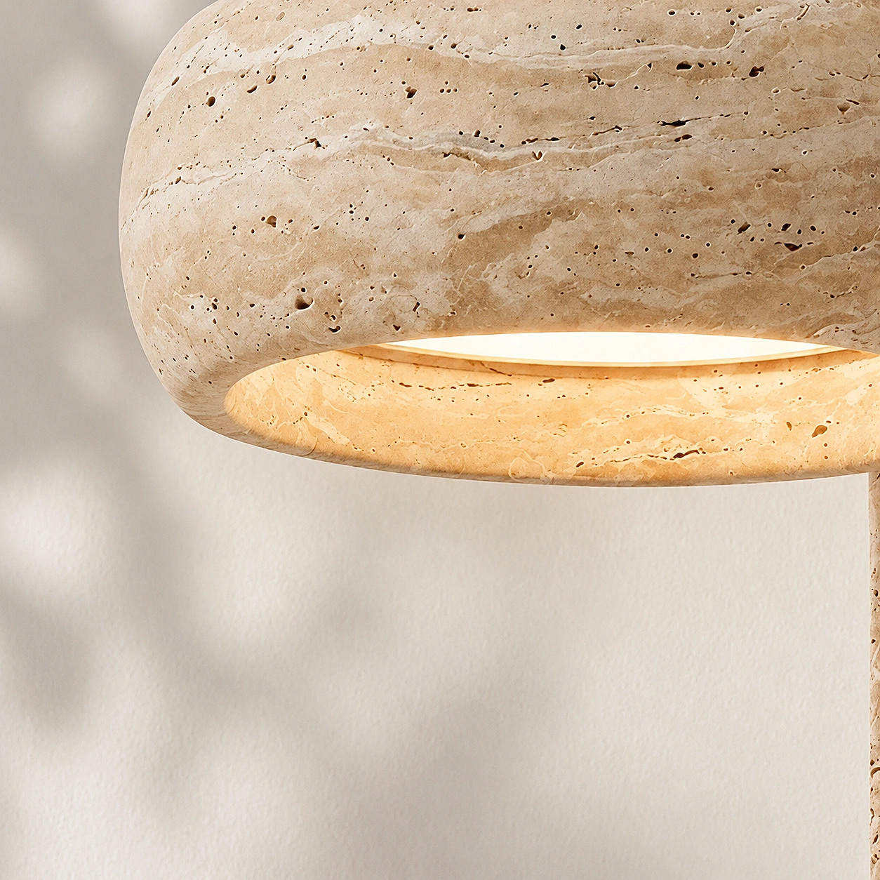 Close detail of travertine stone texture on Maelle wall lamp