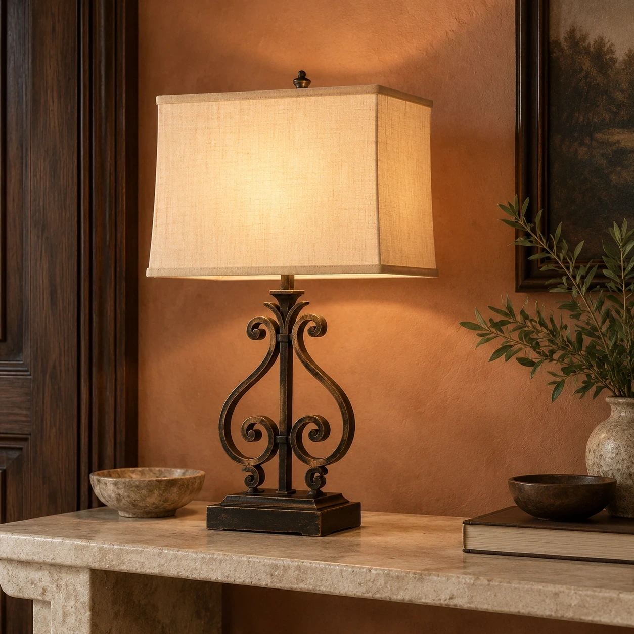 Rothbury ornate table lamp on a pale limestone console against muted terracotta plaster
