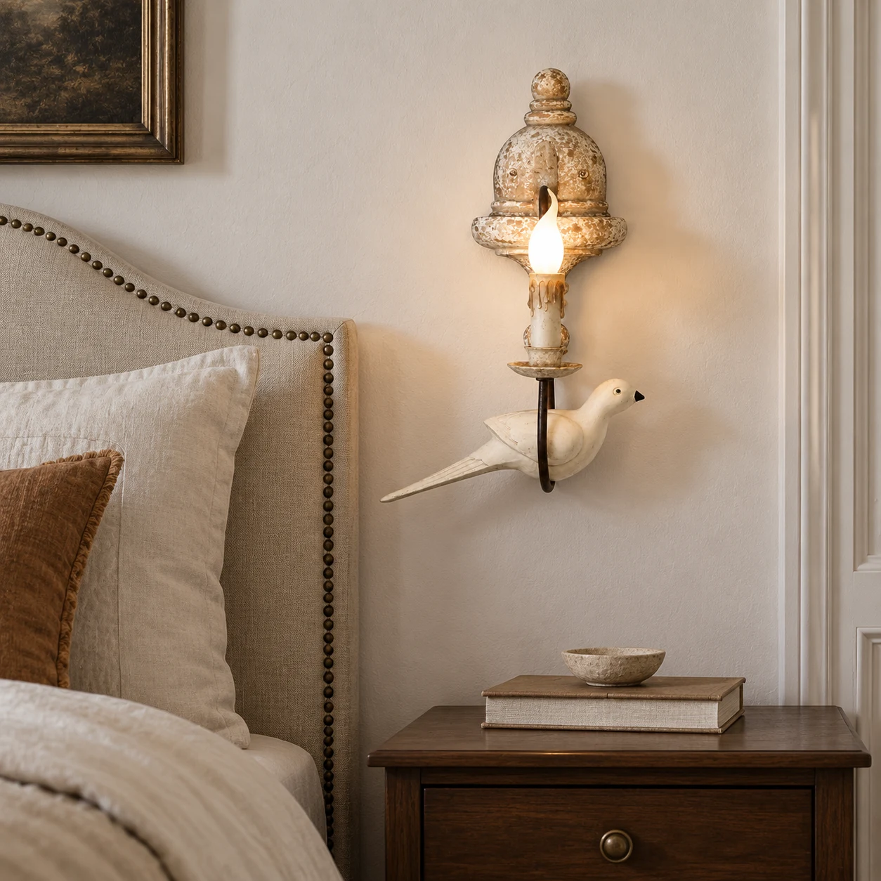 Mara single-head bird wall light beside a linen bed
