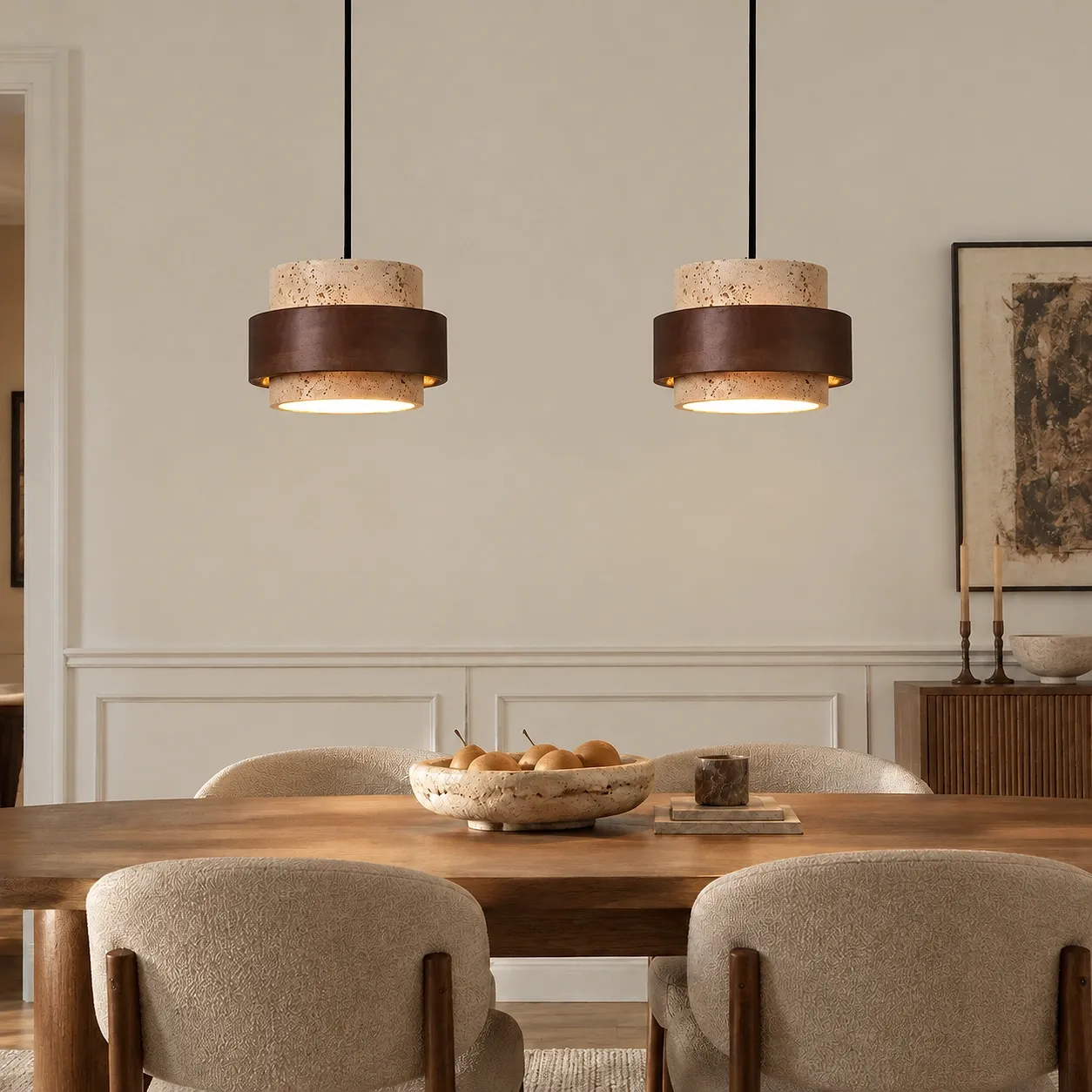 Duas luminárias pendentes de travertino bege acima de uma mesa de jantar