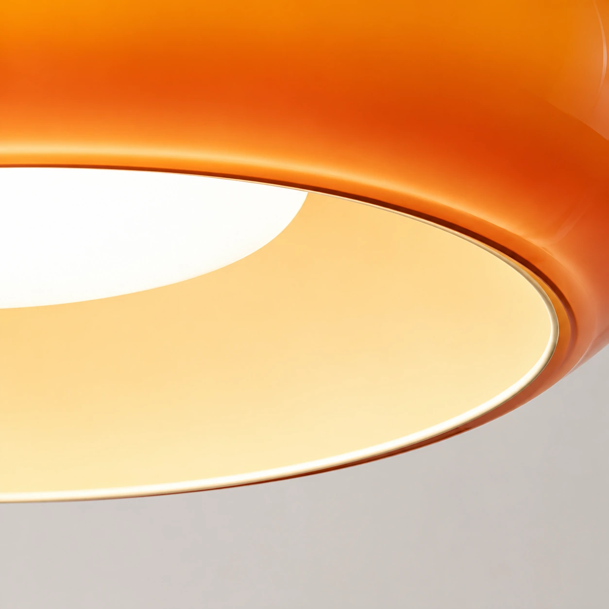 Close-up of the open lower rim and illuminated interior of the orange shade