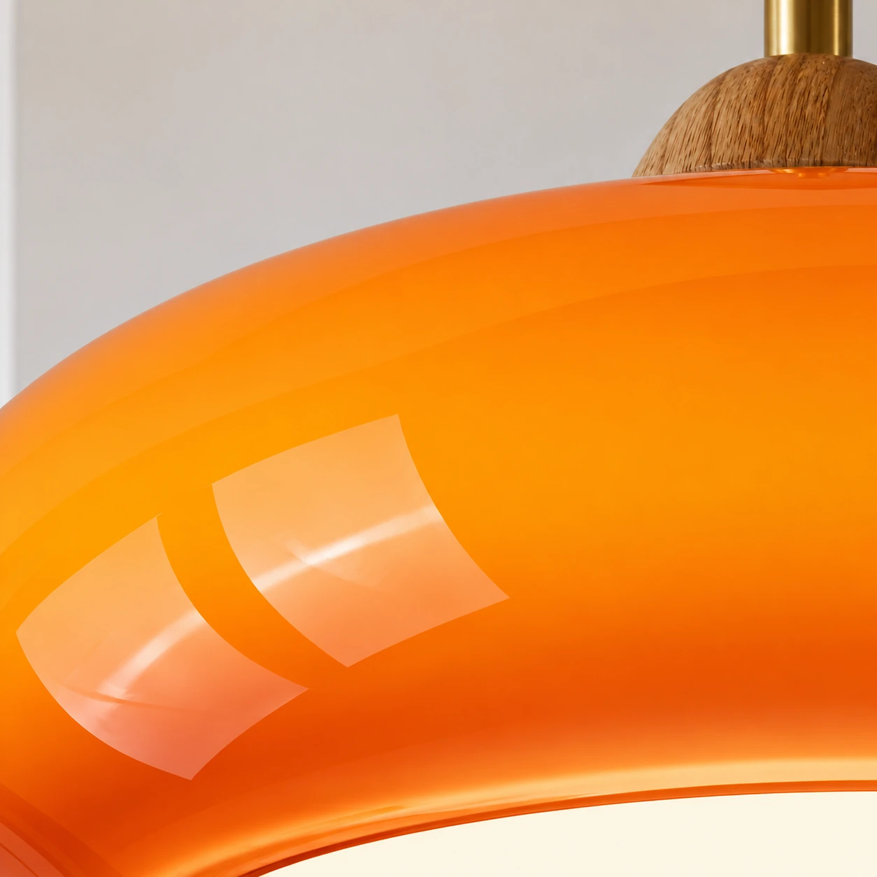 Close-up of the glossy orange glass shade and its smooth curved surface
