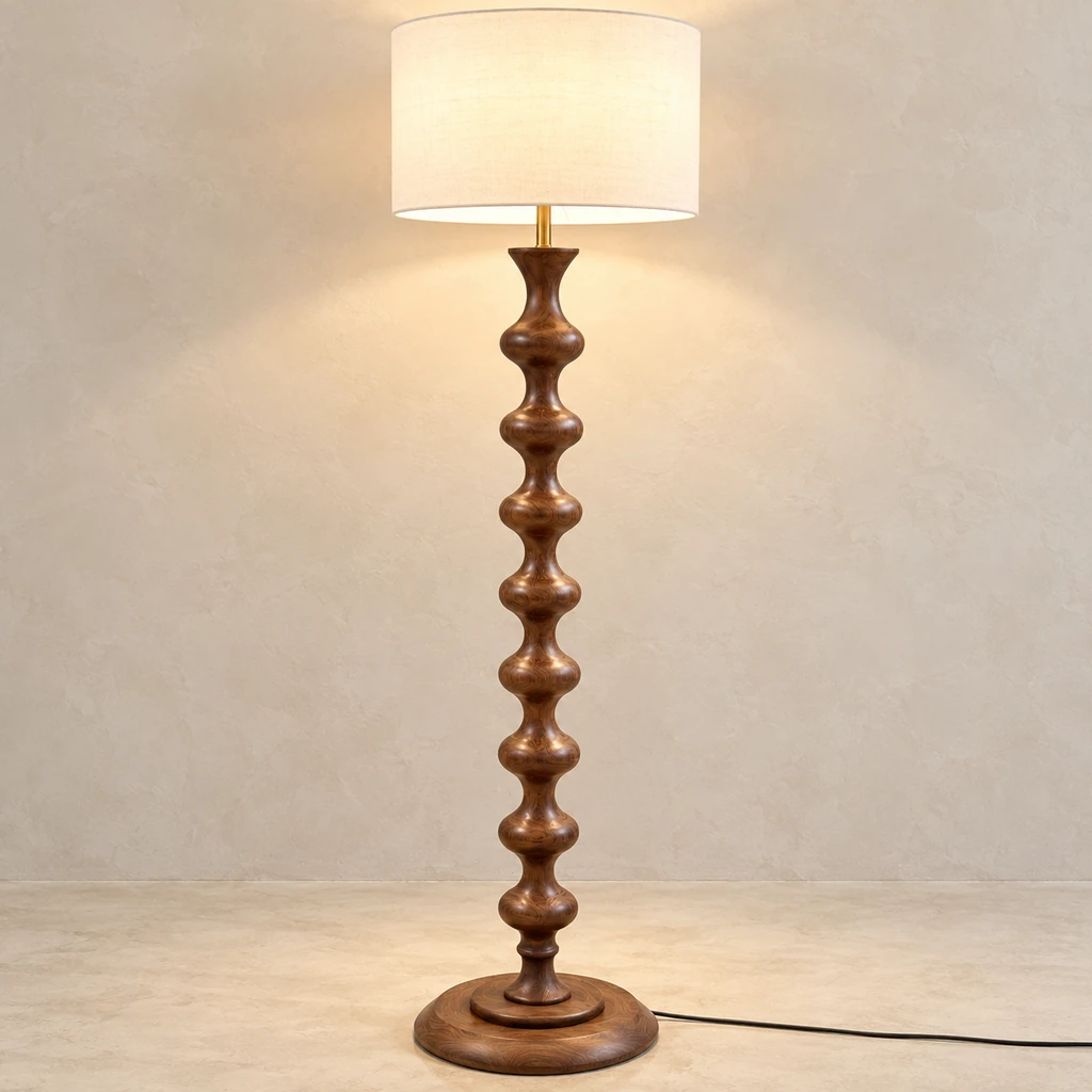 Avery sculpted walnut wood floor lamp illuminated against pale mineral plaster