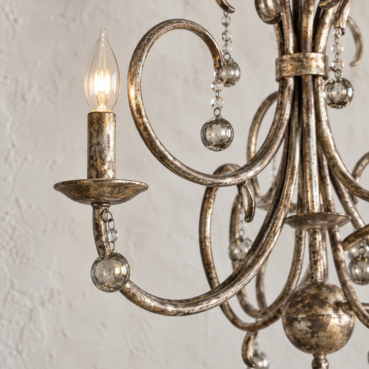 Close detail of aged iron candle cup, curled arm and crystal drops