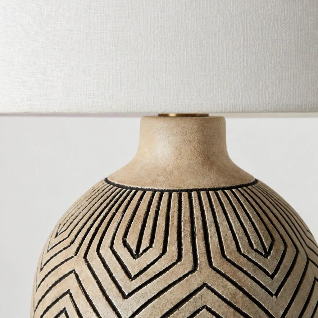Close detail of the white fabric shade, wood neck and patterned lamp body