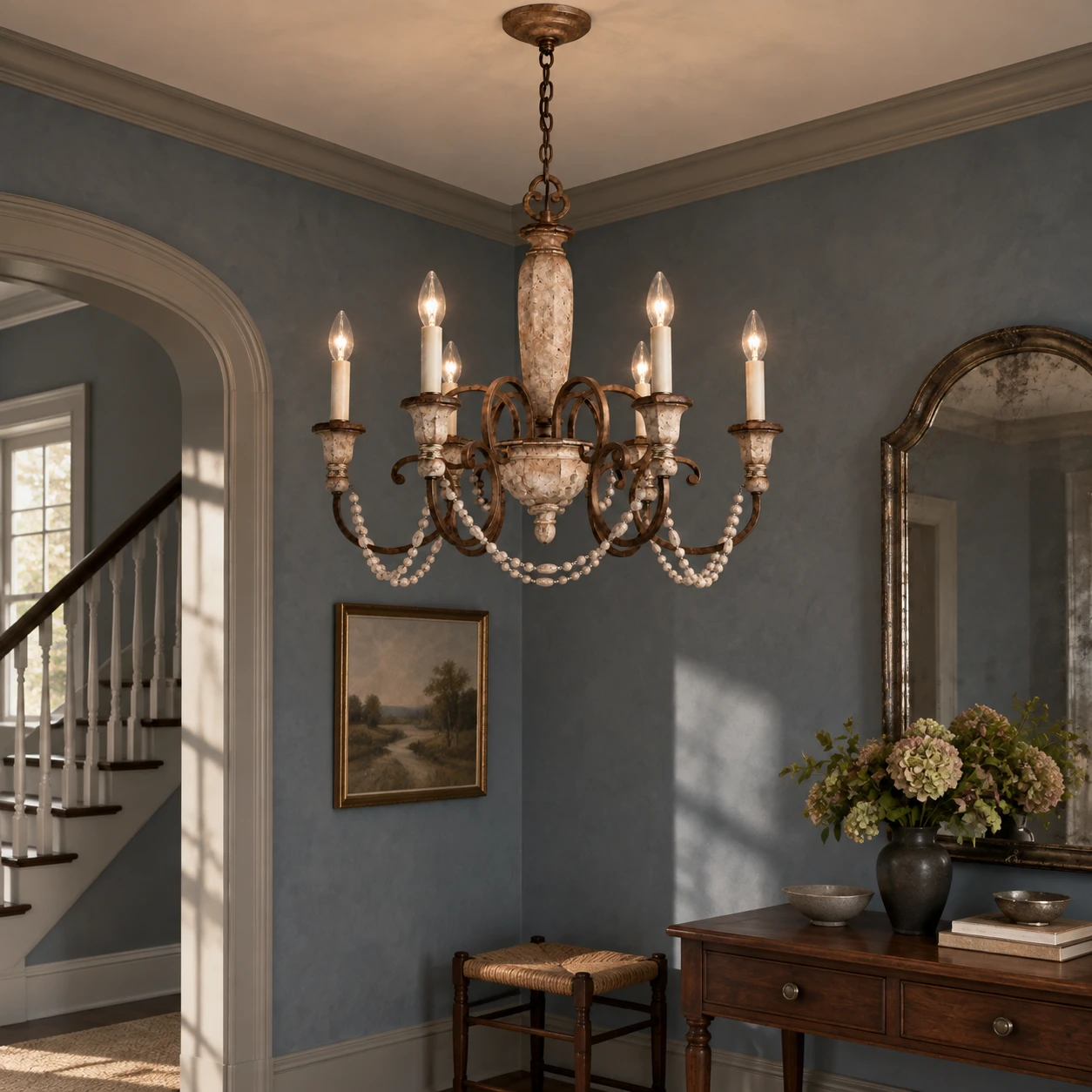Six-light carved wood chandelier in a smoke-blue vintage entry salon