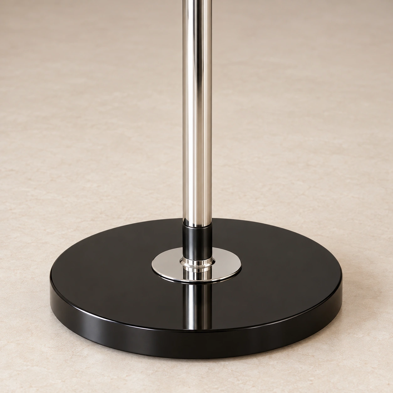 Detail of the chrome-finished stem joining the black circular floor base