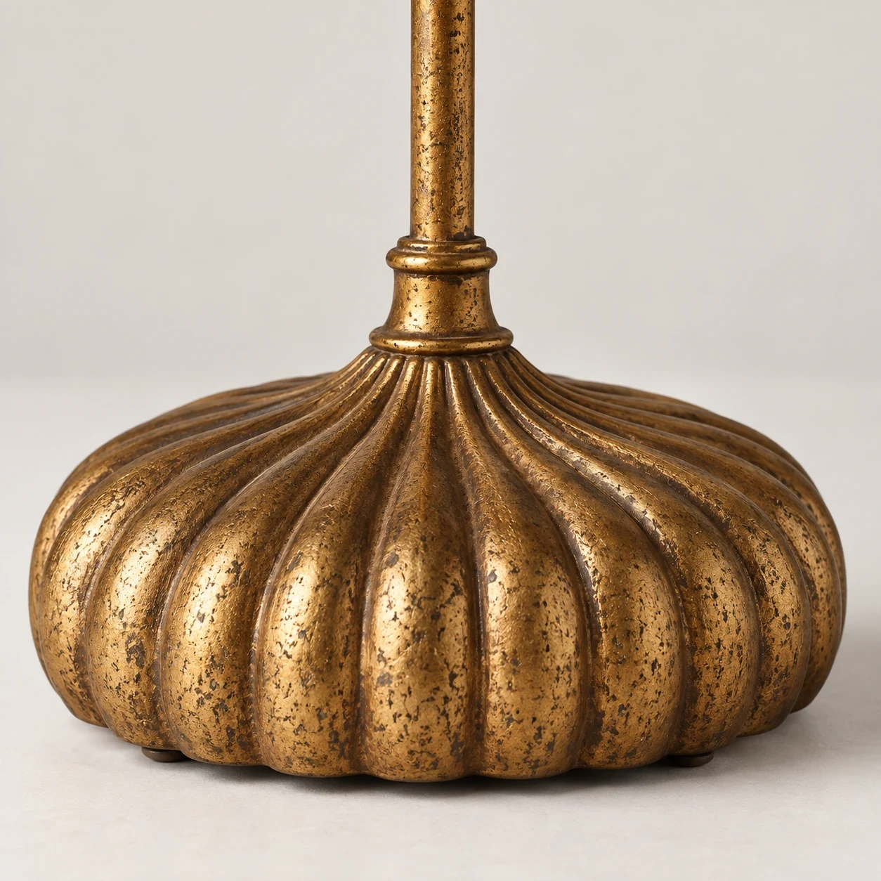 Close view of the fluted distressed-gold iron base on the Clove table lamp