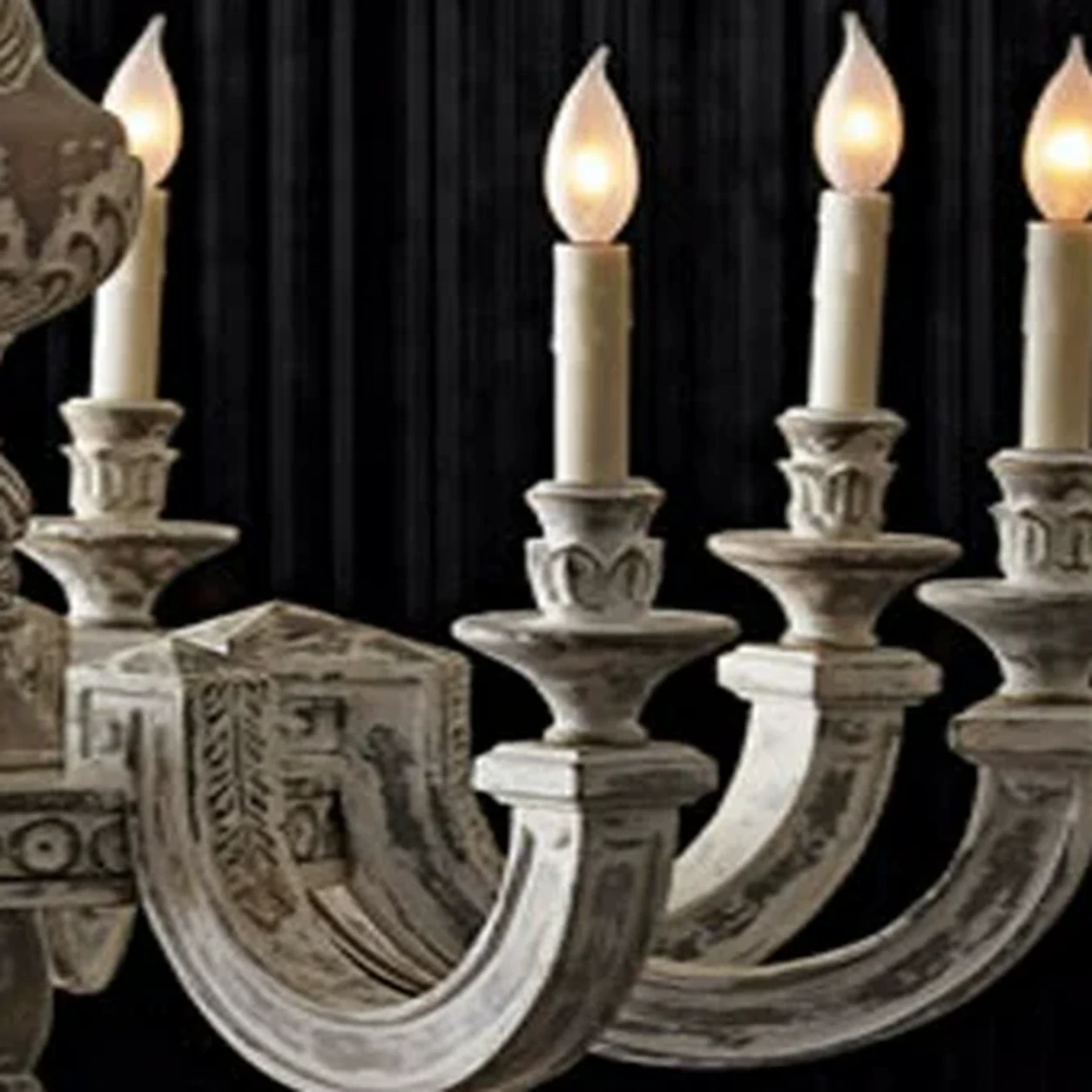 Close view of a candle-style wood arm on the Elowen chandelier