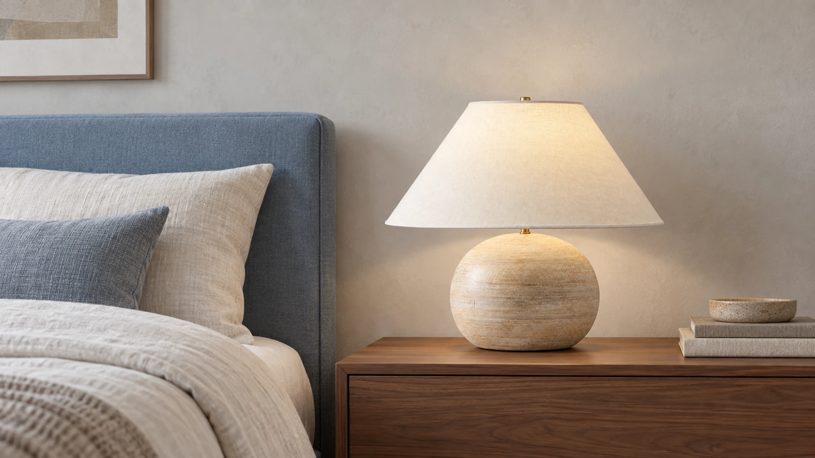 Lámpara de mesa de madera envejecida sobre una mesita de noche en el dormitorio.