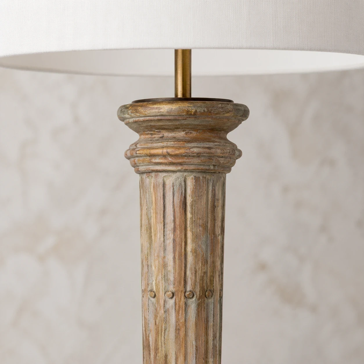 Detalle cercano de la columna superior de madera tallada y collar de capas.