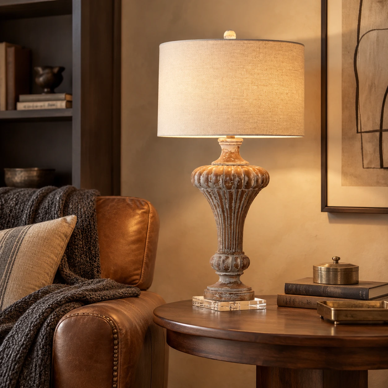 Aurelia carved wood table lamp beside a leather living room chair