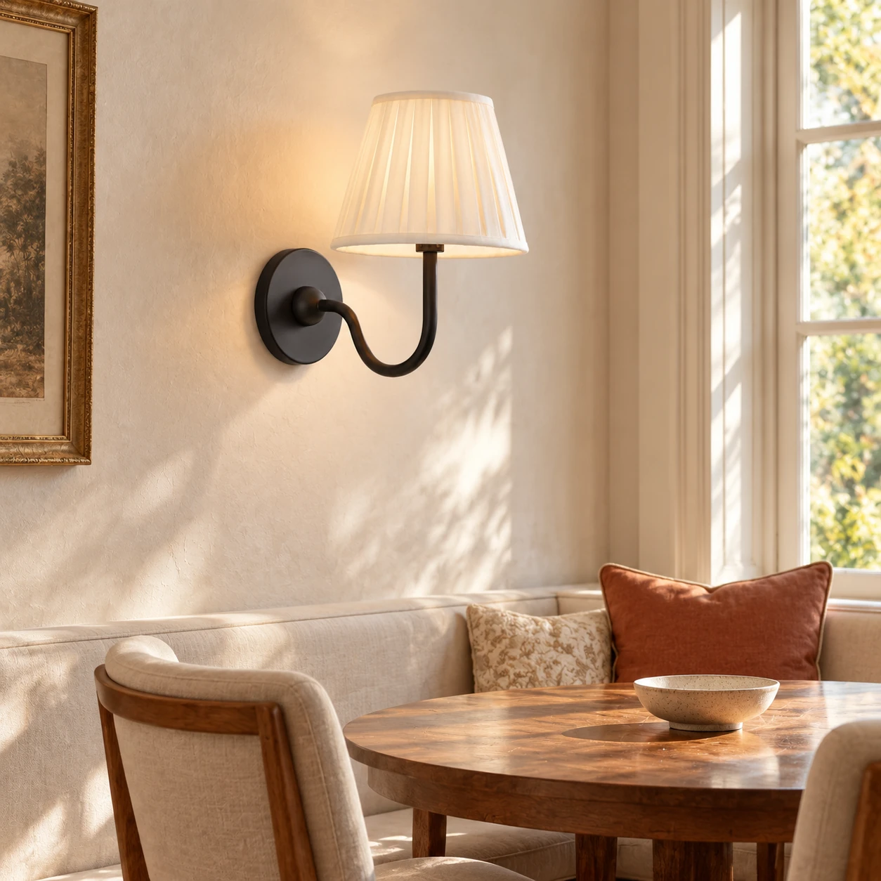 Dans une petite salle à manger, une lampe en tissu rustique américain est placée au-dessus d'une table en bois recouverte d'un enduit minéral clair.