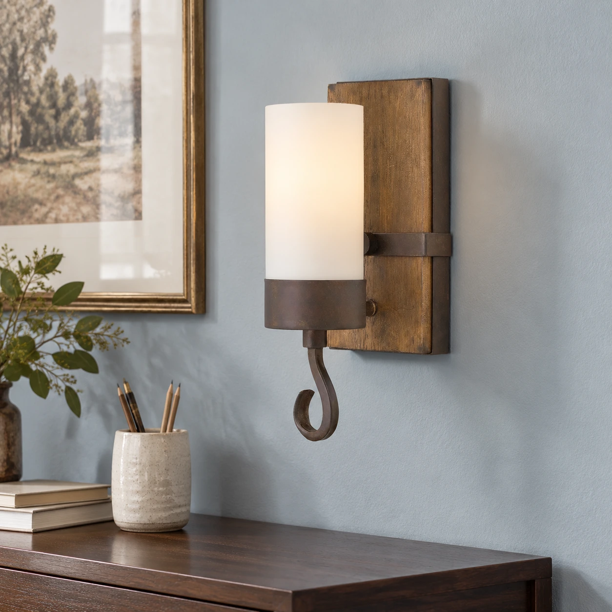 Applique murale en bois sculpté au-dessus d'une console de bureau en noyer avec un mur bleu poudré