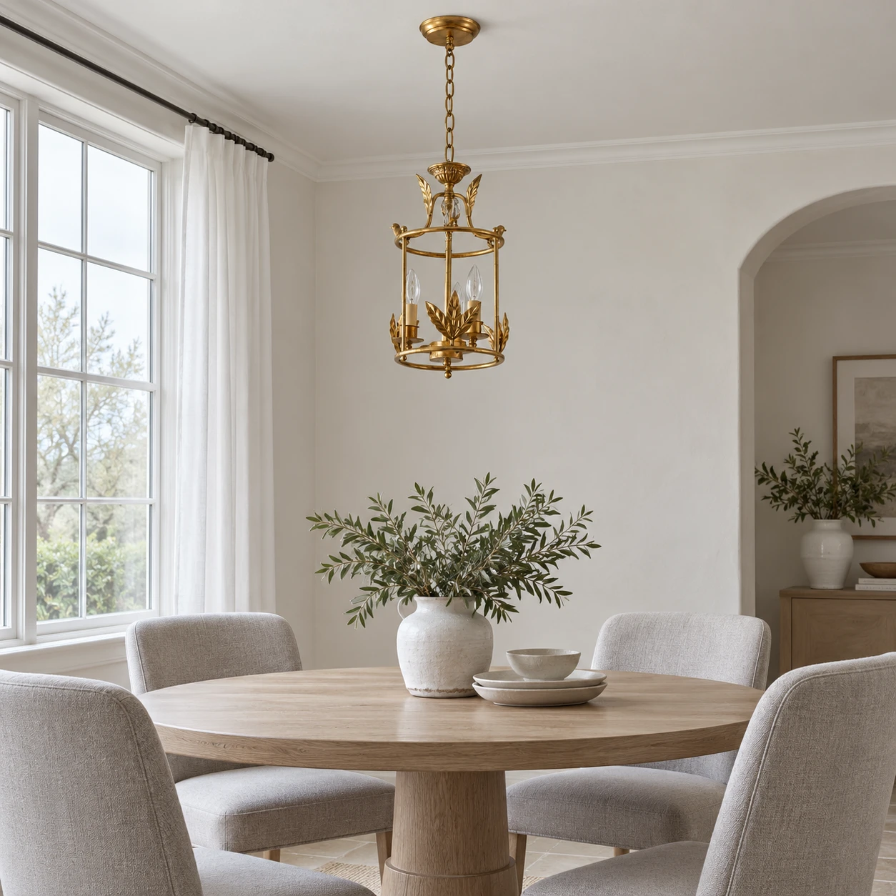 Lustre Margot à trois lumières en cage au-dessus d’une petite table à manger