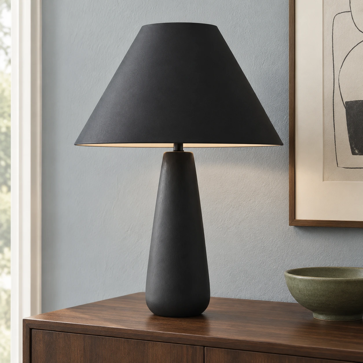 Lampe de table noire posée sur un buffet en noyer