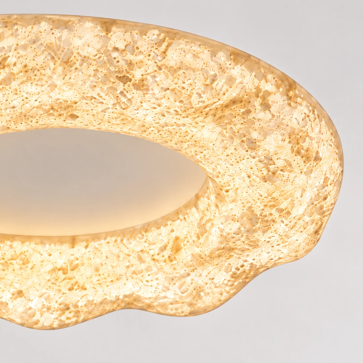 Gros plan sur la bague en résine blanc sable sculptée de Clara et son bord arrondi