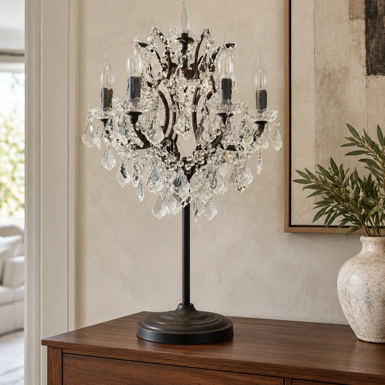 Lampe de table Celeste en cristal, posée sur une console de salon en noyer.