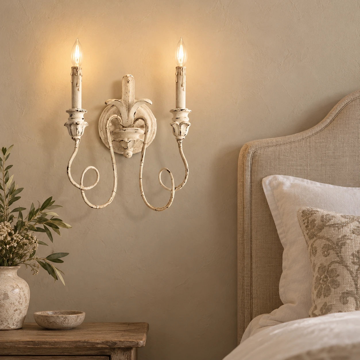 Applique murale Cassia blanche vieillie à côté d'une tête de lit en lin